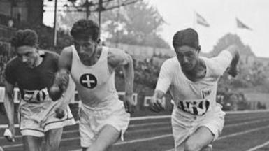 Three sprinters run side by side in men's 1500 metres event at Paris 1924 Summer Olympics