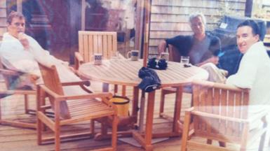 An image of Andrew Mountbatten-Windsor, Jeffrey Epstein and Peter Mandelson sat around a wooden table. 