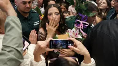 Dara blows a kiss to fans in a busy Sofia airport 