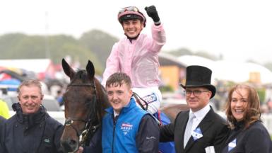 Jockey Ronan Whelan celebrates winning the Derby by punching the air while still saddling Christmas Day as he returns to the paddock