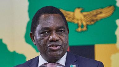 A head and shoulders image of Hakainde Hichilema speaking. A golden eagle from the Zambian flag can be seen behind him.