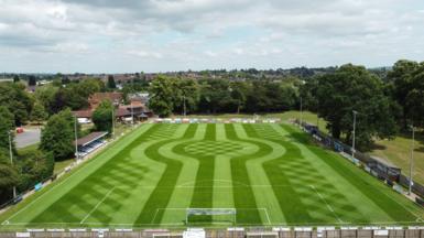 A football pitch with mowing designs including straight lines, curves and diagonal stripes