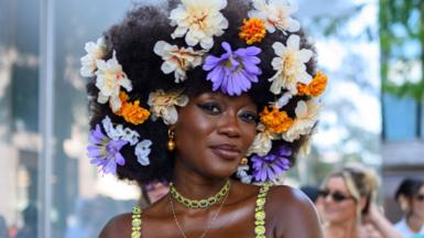 Woman with flowers in her hair and gold jewellery at New York fashion week