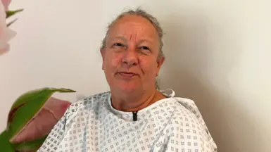 Vanda Instone in a hospital gown looking at the camera