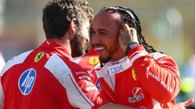 A smiling Lewis Hamilton is congratulated by a Ferrari team member after taking pole position for the British Grand Prix sprint race