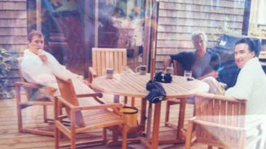 An image of Andrew Mountbatten-Windsor, Jeffrey Epstein and Peter Mandelson sat around a wooden table. 