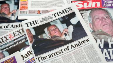 Several UK newspapers spread out showing front pictures of Andrew Mountbatten-Windsor photographed leaving a police station after his arrest