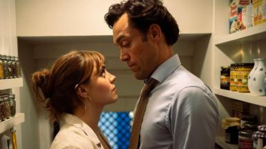 Bella Maclean and Alex Hassell face each other in cupboard