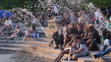 People cooling down near a fountain during extreme heat in New York City