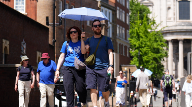 A person uses an umbrella to shelter from the hot weather near St Paul's Cathedral 
