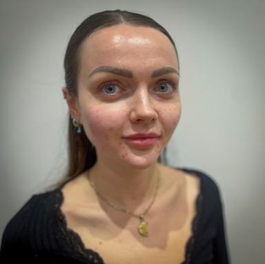 Abby has long brown hair and she is looking straight at the camera