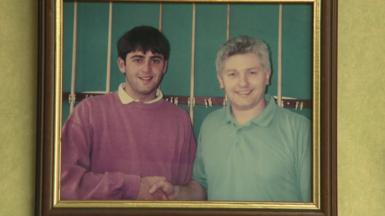 A teenager Ronnie O'Sullivan shakes the hand of snooker cue manufacturer John Parris in an old photograph on a wall at Parris Cues
