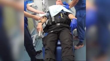 Police officer unconscious in hospital.