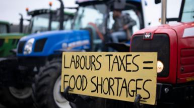 Farmers stage a protest in front of Venue Cymru against a rise in inheritance tax in Llandudno, Wales. A placard on the front of a red tractor reads "Labour taxes = food shortages".