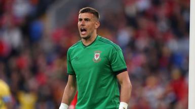 Karl Darlow stands in short-sleeved green Wales goalkeeper shirt