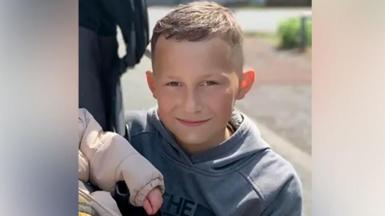 Layton Carr is smiling into the camera. He has short brown hair and is wearing a grey top. 