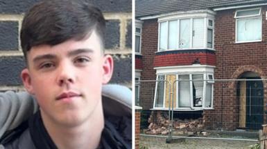 On the left is Cole Worthy, a teenager with a dark fringe-style haircut with faded back and sides. On the right is a semi-detached house with a smashed front bay window. The brickwork beneath the window has collapsed. A construction fence surrounds the front of the property.