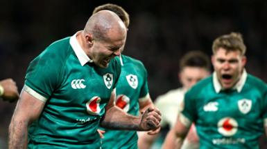 Shaven-headed Jacob Stockdale clenches his left fist and appears to shout out in delight as he celebrates his try for Ireland