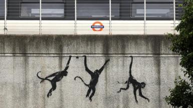 Banksy's three monkeys, on a bridge on Brick Lane