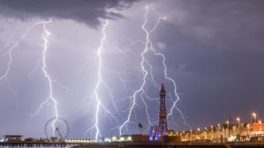 Blackpool tower surrounded by strikes of lighting at night.