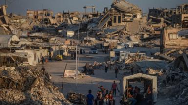 Displaced Palestinians walk between destroyed houses in Jabaliya, northern Gaza City, 07 August 2026. 