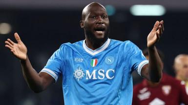 Romelu Lukaku in Napoli's light blue shirt, with raised arms held out in front of him