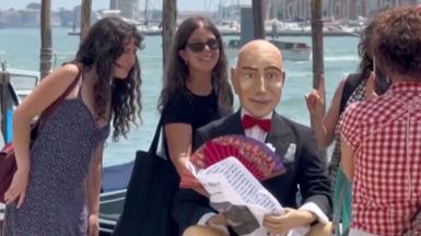 People pose for a photo with a Jeff Bezos mannequin
