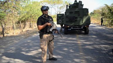 Dyn yn sefyll gyda dryll