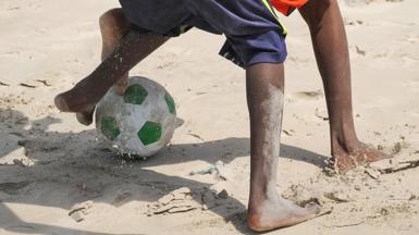Boys playing football on a beach in Mogadishu, Somalia