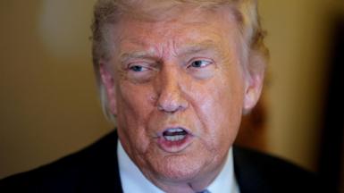 Donald Trump speaks to the press aboard Air Force One 