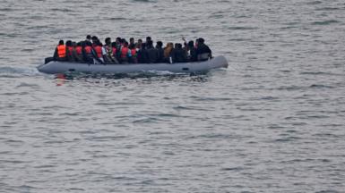 An inflatable boat, filled with migrants, attempting to cross the Channel