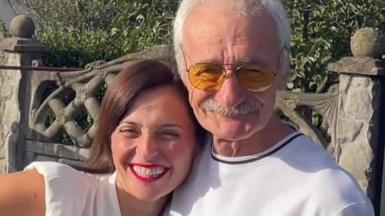 Tamuna with her father Gurgen. They are both smiling and are standing close together - she has her head on his shoulder. She has long straight dark hair and is wearing a white top. He has white hair and a moustache. He is wearing glasses and a white top.