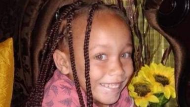 Joshlin Smith, with her hair in plaits and wearing a pink top, smiles at the camera