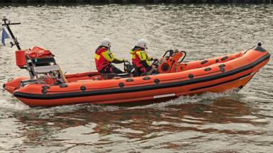 Close up of RNLI staff on a lifeboat in the sea