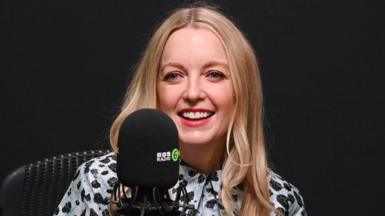 Lauren Laverne smiling in front of a 6 Music microphone in a radio studio
