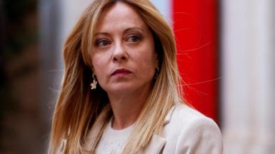 Italian Prime Minister Giorgia Meloni looks on