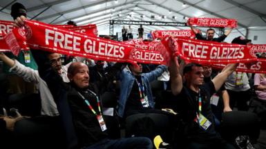 Journalists hold up scarves reading 'Free Gleizes' in support of French sports journalist Christophe Gleizes before the the start of the France press conference at New Jersey New York Stadium