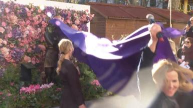 Actress Sally Phillips pulling purple rug and unveiling Bridget Jones statue