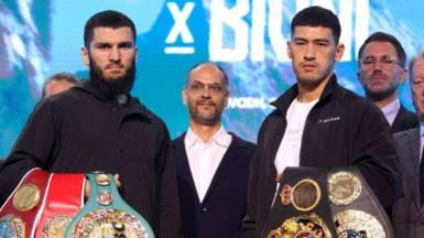 Artur Beterbiev and Dimitry Bivol pose with their belts at a news conference