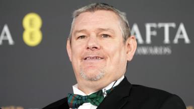 John Davidson in a bow tie on the Baftas red carpet