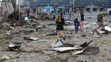 People walk among debris in Kyiv, following overnight Russian missile and drone strikes on Ukraine's capital. Photo: 24 May 2026