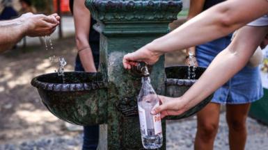 Tourists fill up their water bottles in Italy.