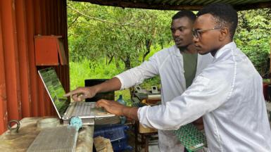 two men working on computers in a remote location