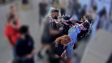 A video grab image issued by the Crown Prosecution Service 
from CCTV footage at Manchester Airport which has been played to jurors at Liverpool Crown Court. Three officers are standing around Mohammed Fahir Amaaz while his brother is standing behind them. One of the officers as his hand on the back of Amaaz's neck. 