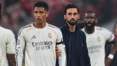 Real Madrid's Jude Bellingham is held back by manager Alvaro Arbeloa after they are knocked out of the Champions League by Bayern Munich
