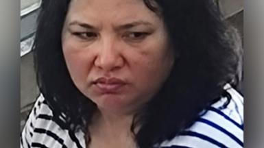 Close-up view of a woman with dark hair and a stripey t-shirt