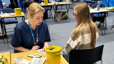 A student about to receive the Meningitis B vaccine at the University of Kent sports hall