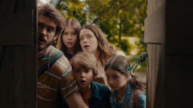 A family looks in awe through an open old door