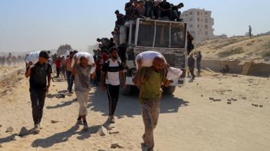 Palestinians carry aid supplies that entered Gaza through Israel. 