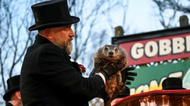 Punxsutawney Phil being held by one of the "inner circle"